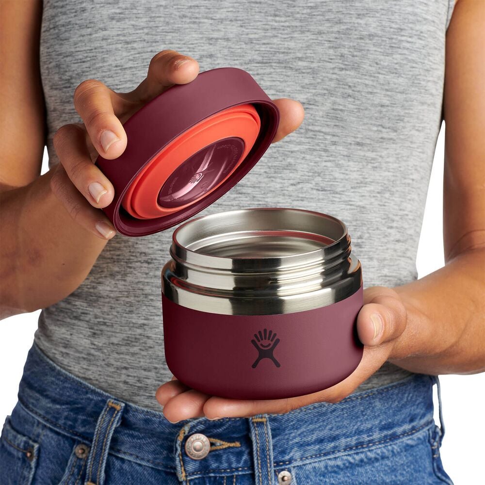 Maroon Hydro Flask cylindrical insulated food container with matte finish, brushed stainless-steel band around the middle, and Hydro Flask logo on front.